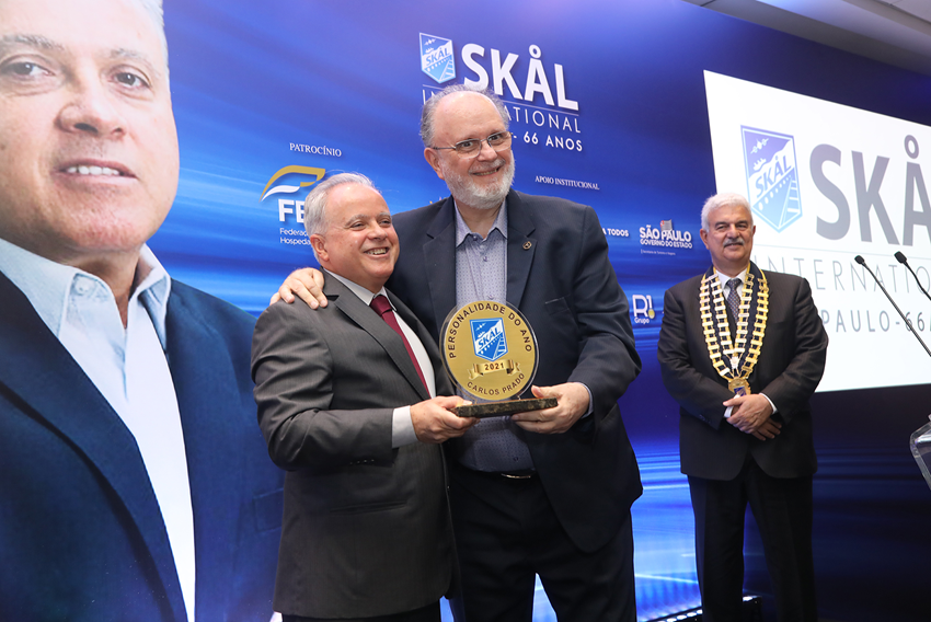 Carlos Prado receives the 2021 SKÅL Personality trophy from Sérgio Junqueira, the last SKÅL Personality in 2019. Carlos Prado receives the 2021 SKÅL Personality trophy from Sérgio Junqueira, the last SKÅL Personality in 2019.